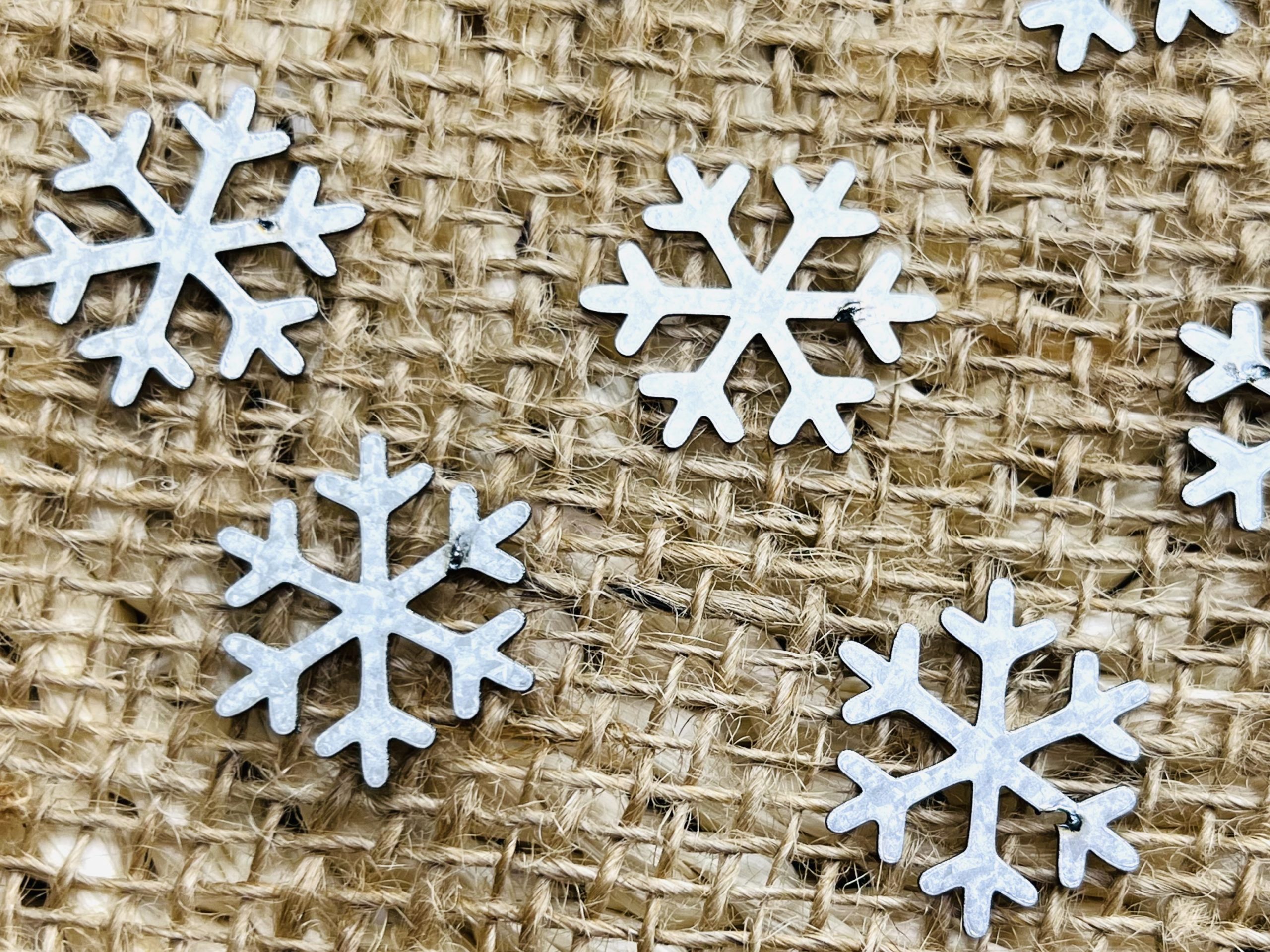small galvanized snowflakes with imperfections for creative and crafting purposes