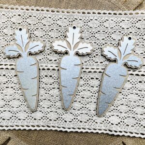 Three separate carrot wood cutouts featuring metal overlays for the top of them that you can craft with