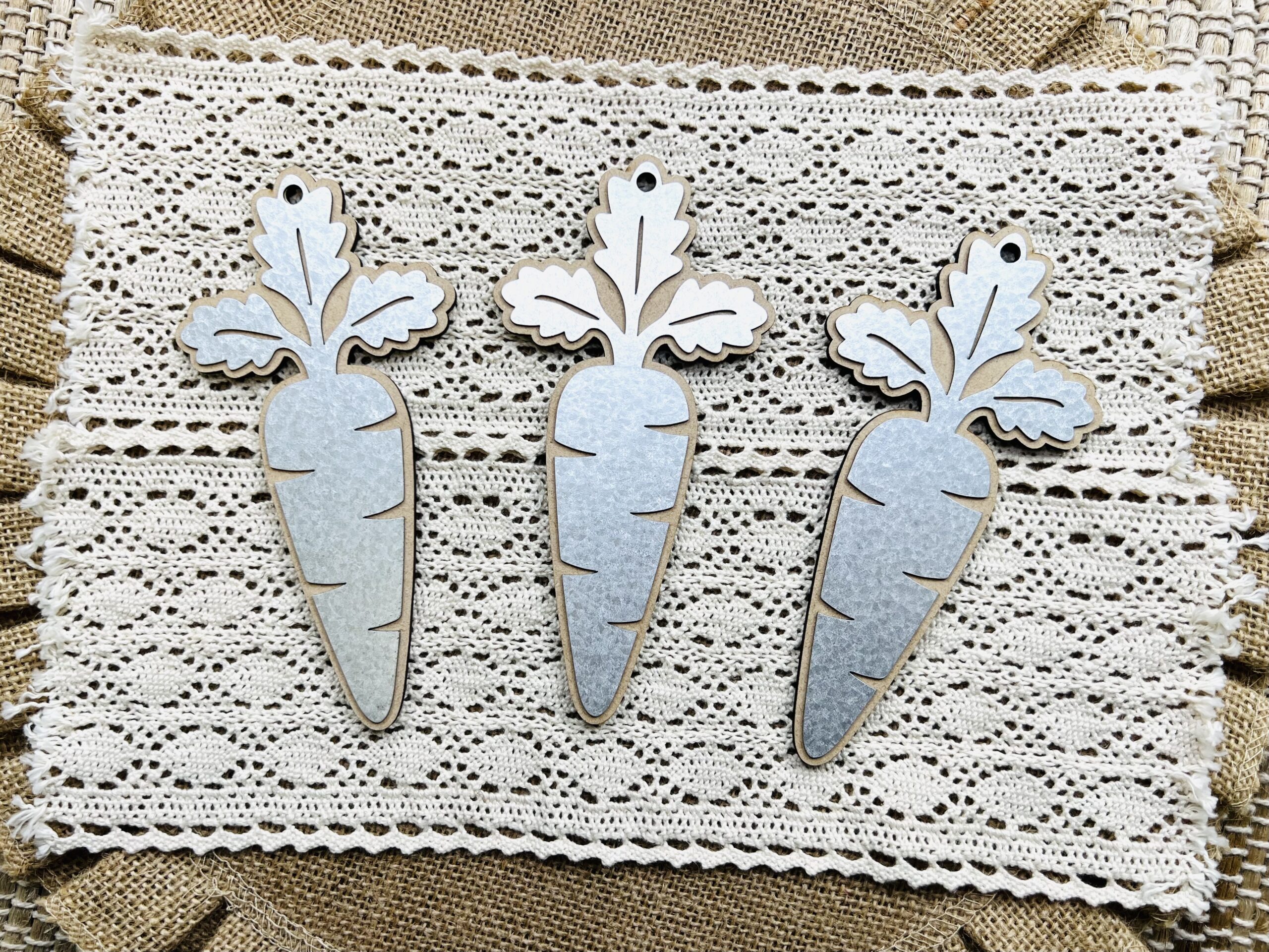 Three separate carrot wood cutouts featuring metal overlays for the top of them that you can craft with