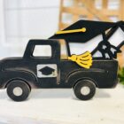 This is a farmhouse truck with an interchangeable graduation hat theme for crafting. This is a finished painted variation of the cutout set.
